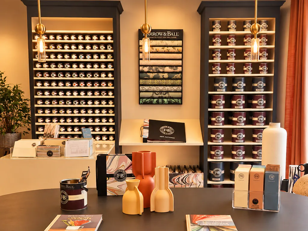 Le mur de pots échantillons Farrow & Ball du Comptoir, à côté des papiers peints et de la bibliothèque de pots