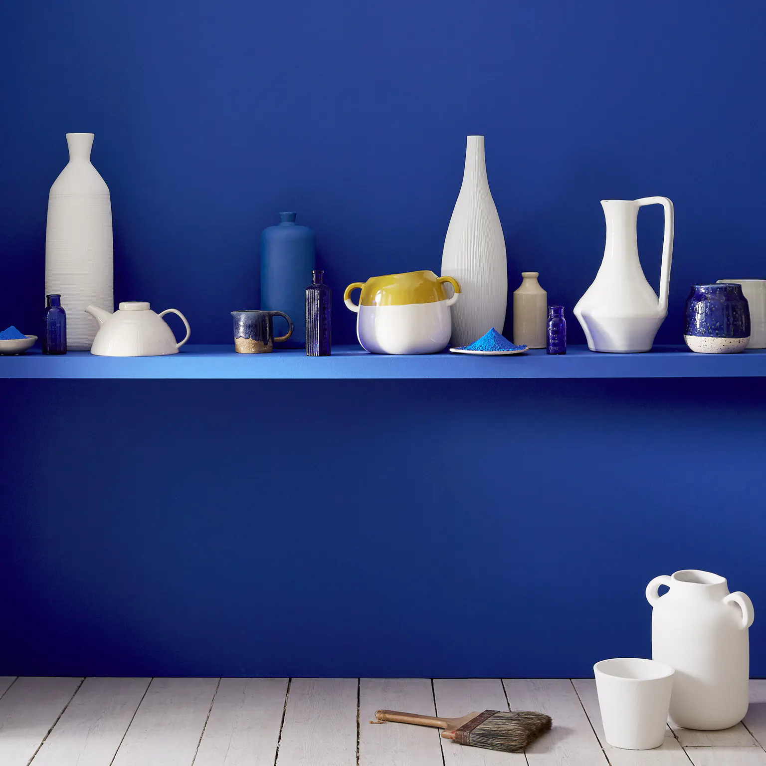 Vases et pichets en céramique blanche sur une étagère bleu outremer
